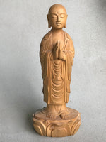 Load image into Gallery viewer, Hand carved wood statue of Jizo man with his palms together, standing on a lotus. 
