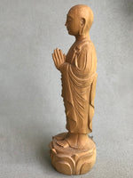 Load image into Gallery viewer, Hand carved wood statue of Jizo man with his palms together, standing on a lotus. Side view
