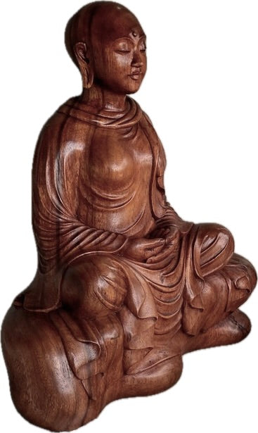 Wooden sculpture of a Buddhist nun seated in meditation.