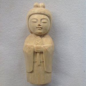 5 inch tall light colored wood hand carved statue of a Japanese Kuan Yin, knows as Kannon, holding a lotus.