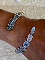 Load image into Gallery viewer, Silver colored dragon bracelet wrapped around a wrist showing the dragons head and tail.
