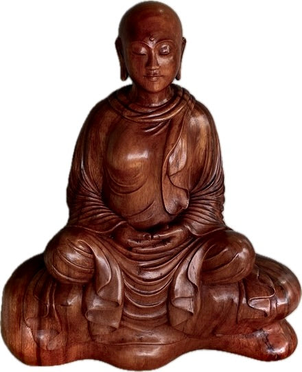 Wooden sculpture of wooden Buddhist nun seated in meditation front view white background