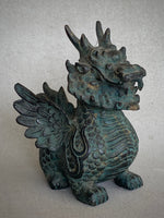 Load image into Gallery viewer, A detailed winged dragon figurine with a textured green patina finish, standing on a neutral gray background,3/4 view.
