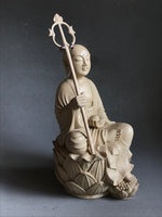 Load image into Gallery viewer, Hand carved light wood statue of Jizo Bodhisattva seated on a lotus staff in one hand and wish fulfilling gem in the other three quarter view
