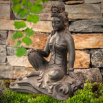 Load image into Gallery viewer, Quan Yin Royal Ease statue warm brown antique rust patina 10 inches tall seated in a garden
